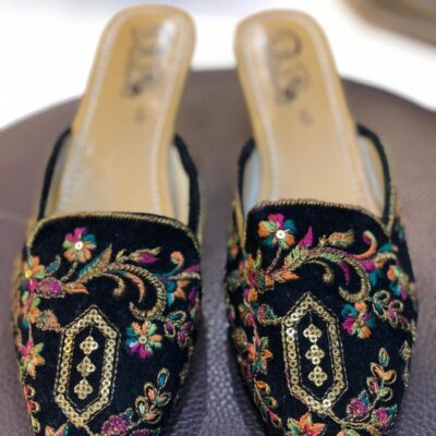Black open khussa with colorful floral thread embroidery and gold sequin medallion, slingback style