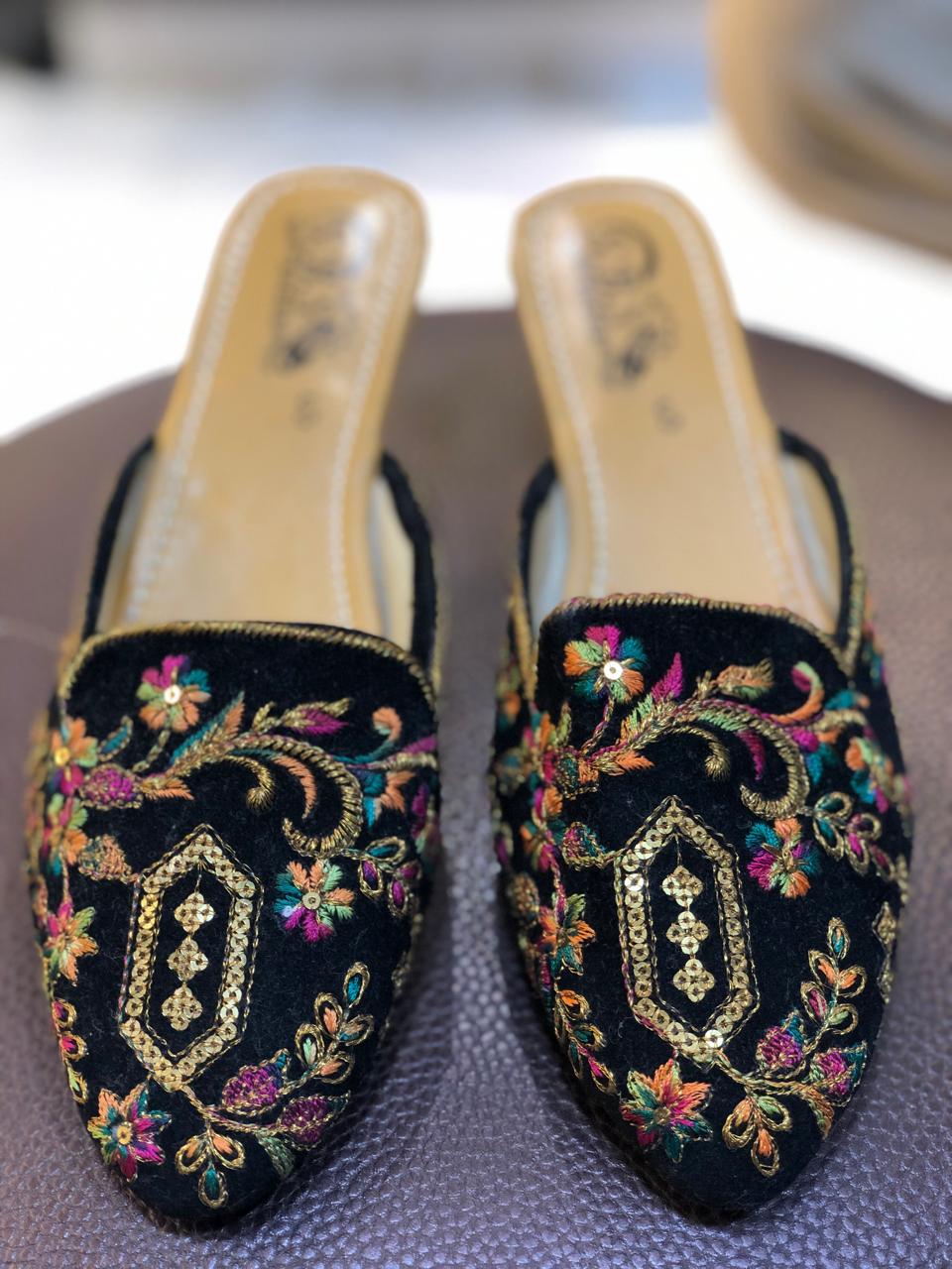 Black open khussa with colorful floral thread embroidery and gold sequin medallion, slingback style